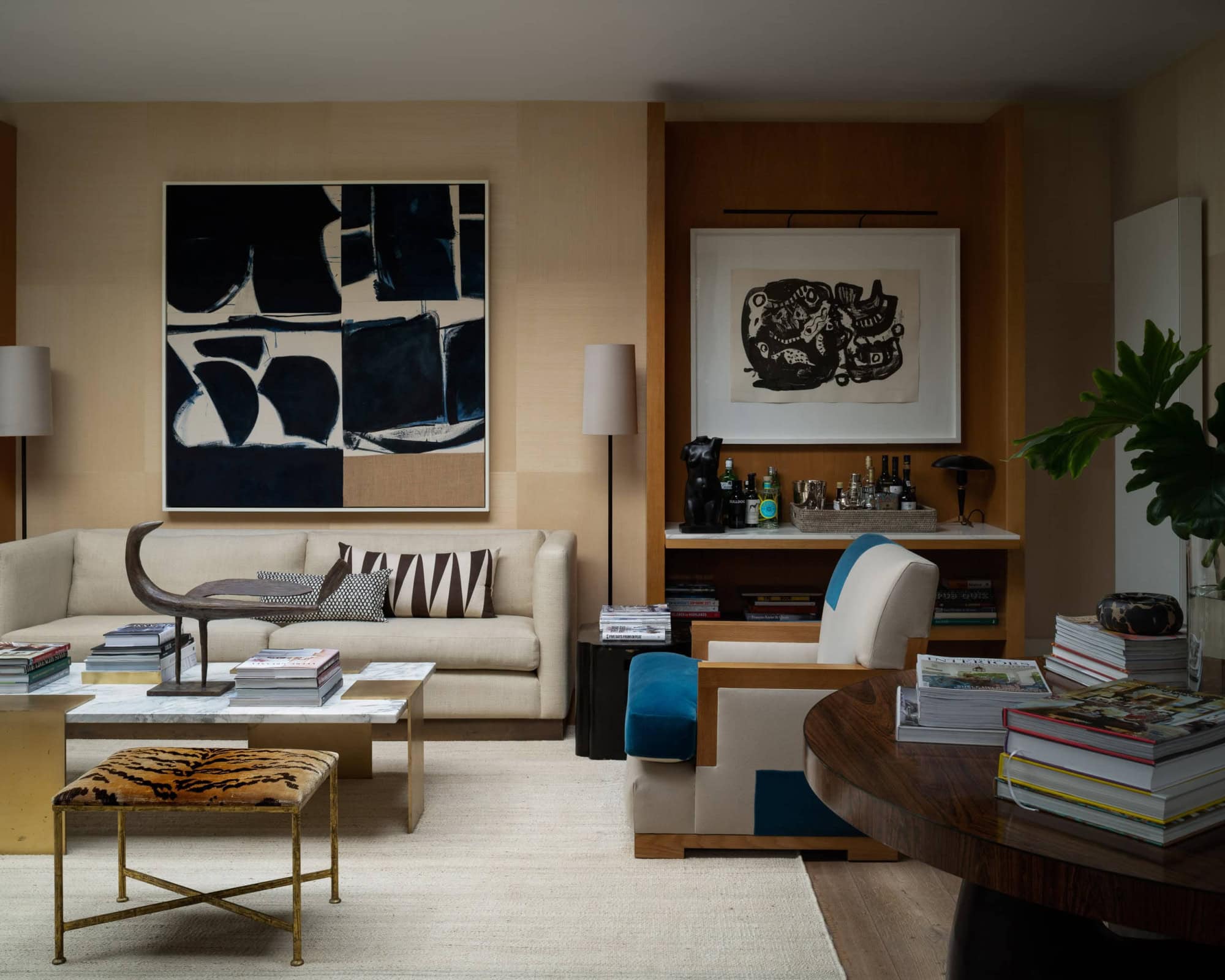 Modern living room with abstract art, cozy seating, and decorative accents.
