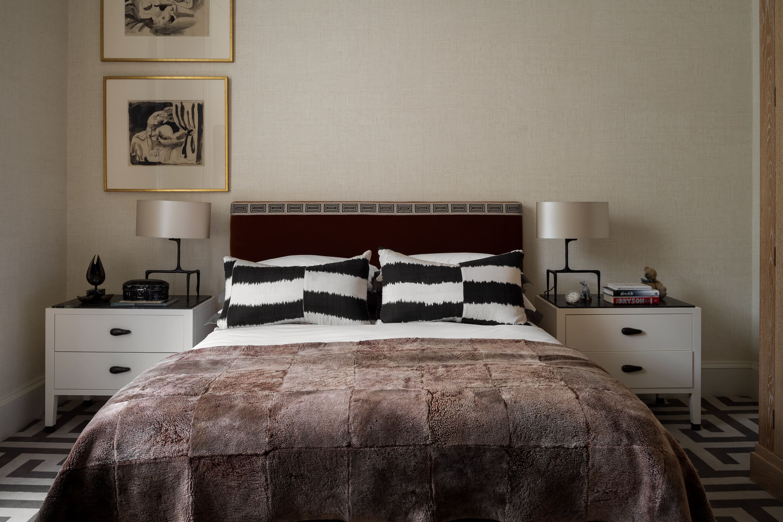Soft beige bedroom with modern decor, black and white cushions, and stylish bedside tables for a cos.