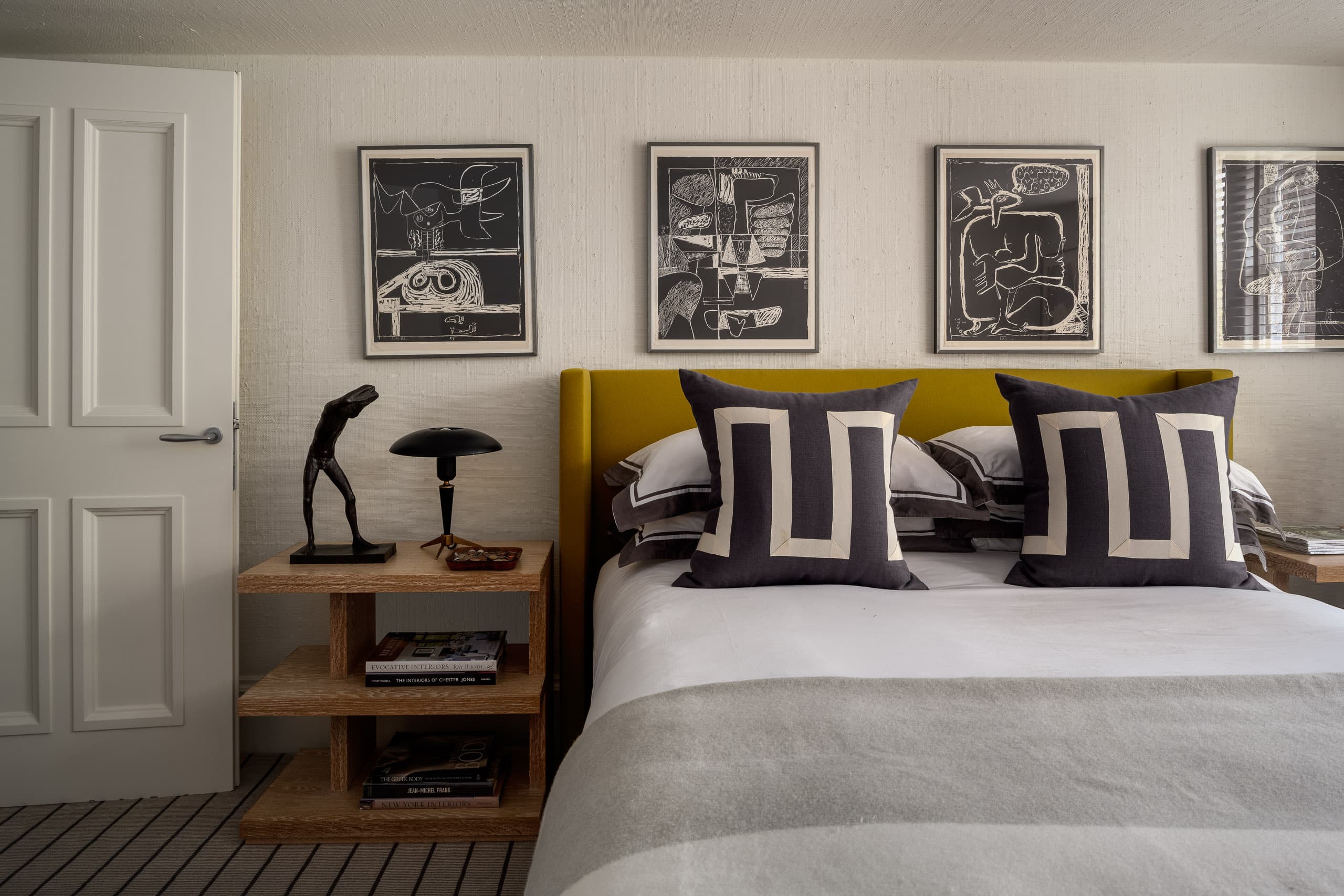 Modern bedroom with colourful artwork and stylish decor, cosy and inviting atmosphere.