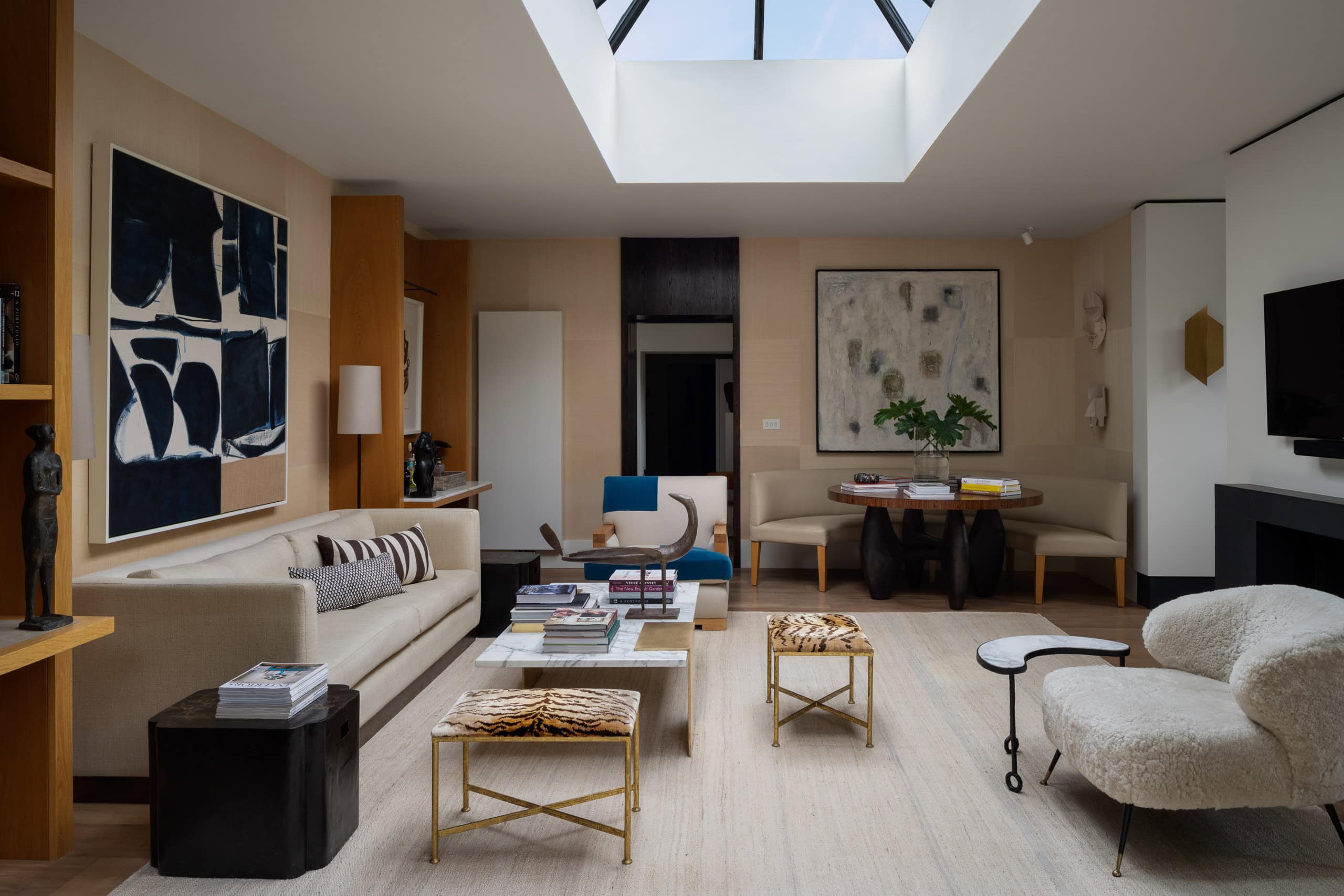 Modern living room with skylight, contemporary furniture, and abstract artwork for stylish home deco.