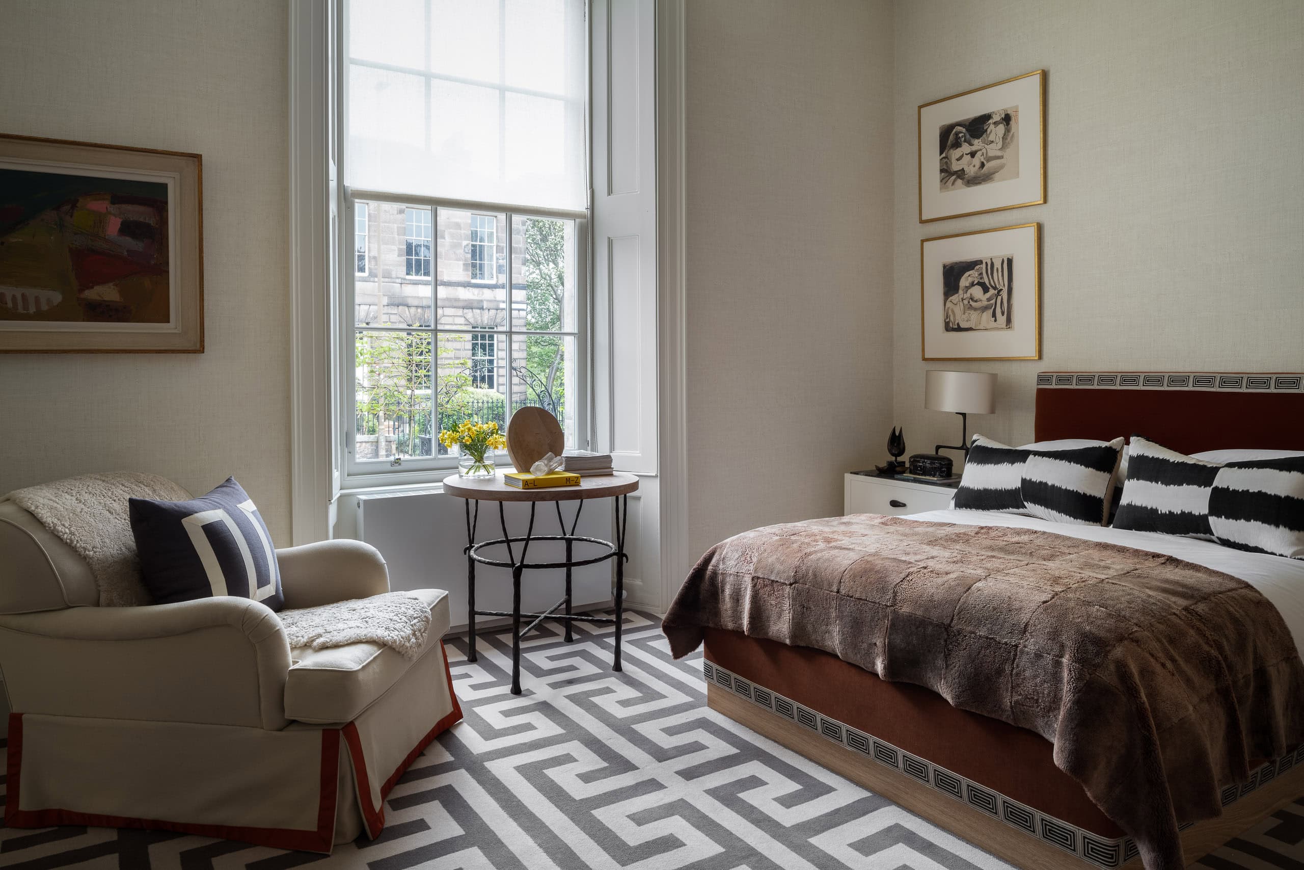 Elegant bedroom with large window, modern decor, and stylish furniture in a bright, airy space.