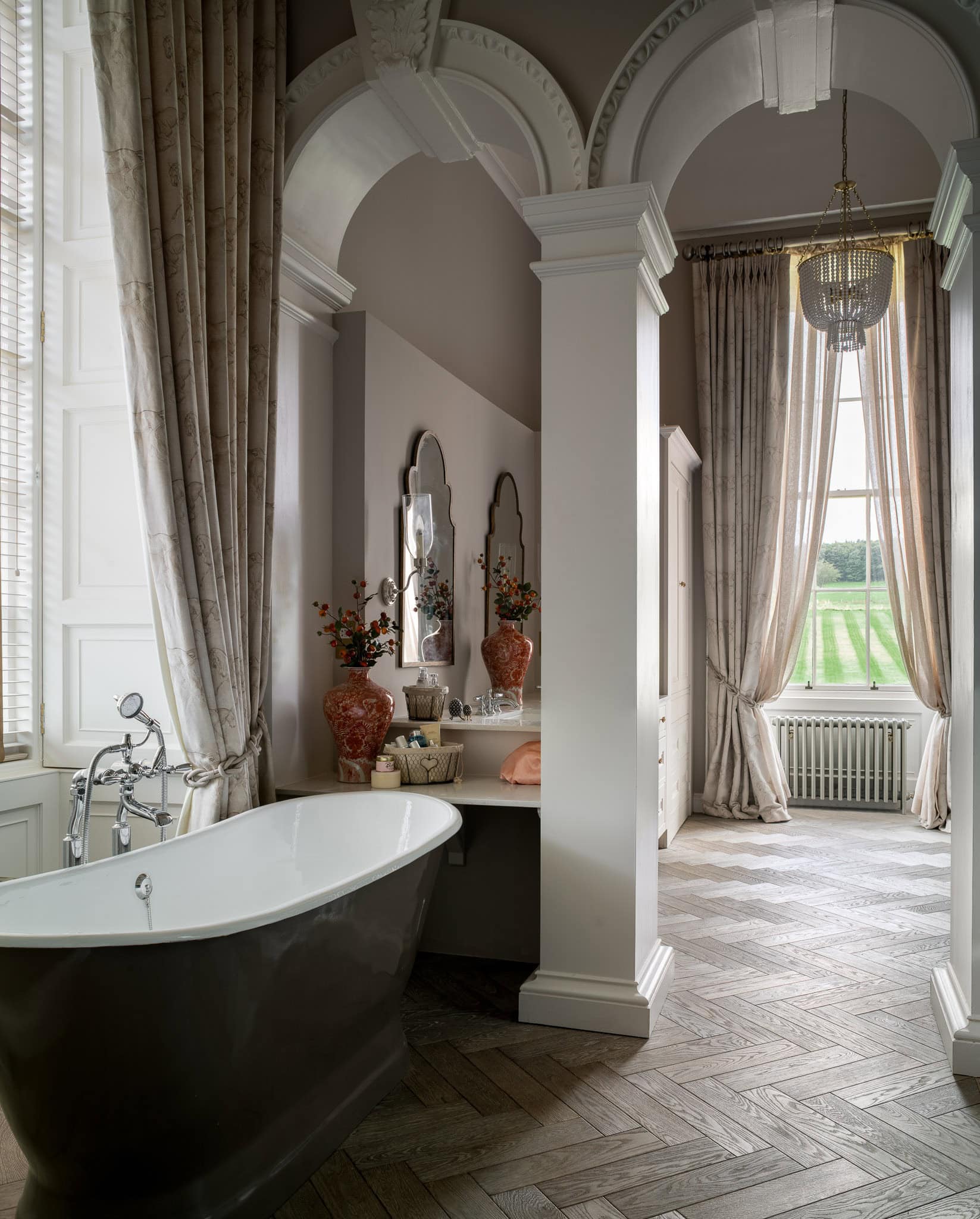 Elegant Victorian-style bathroom with a freestanding bathtub, ornate mirrors, and luxurious drapery.