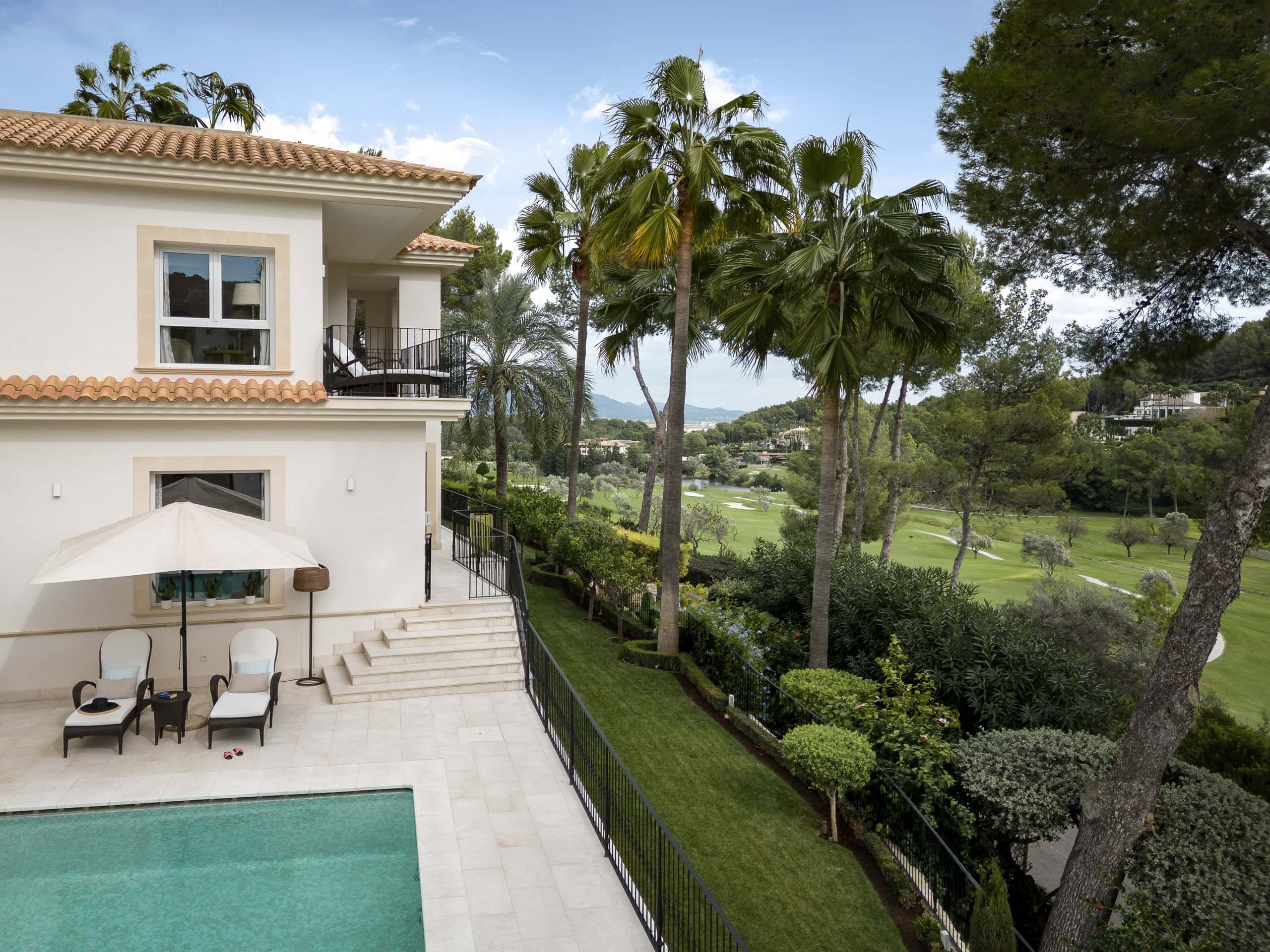 Luxury villa with private pool and lush tropical garden overlooking a golf course in sunny Mallorca