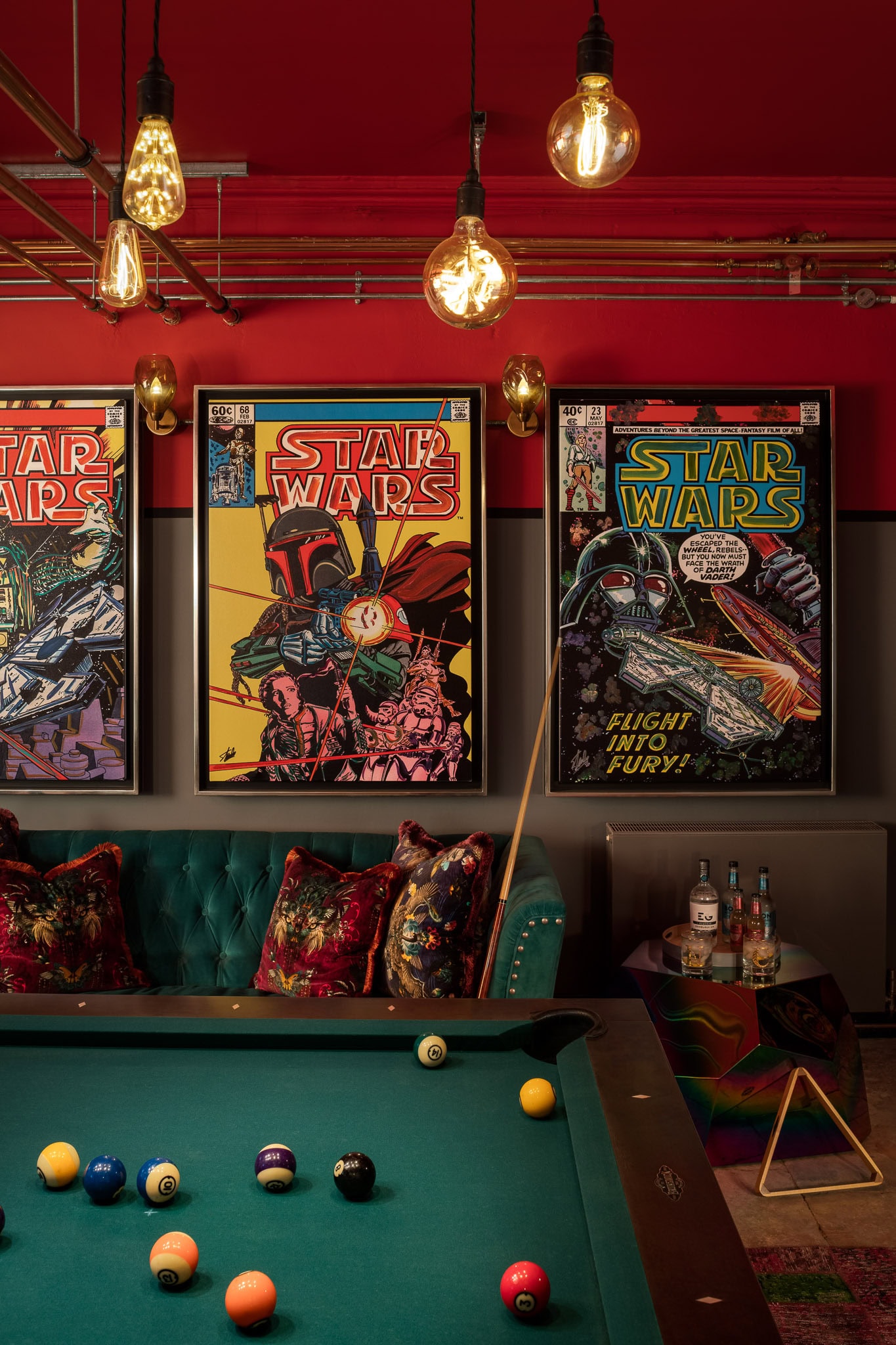 Vintage Star Wars posters hanging in a stylish lounge with pool table and warm lighting.