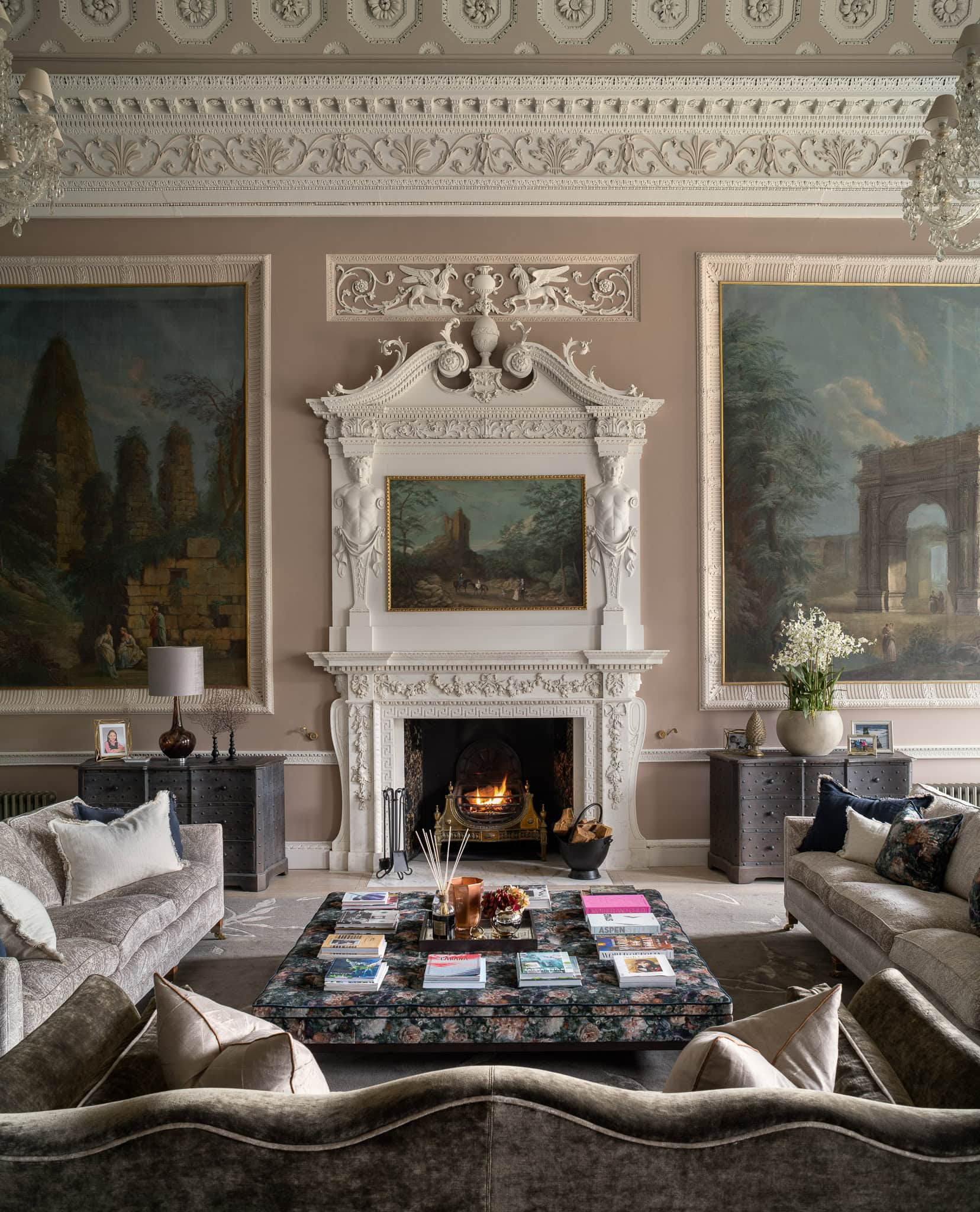 Elegant Victorian-style living room with ornate fireplace, classical paintings, and luxurious furnis.