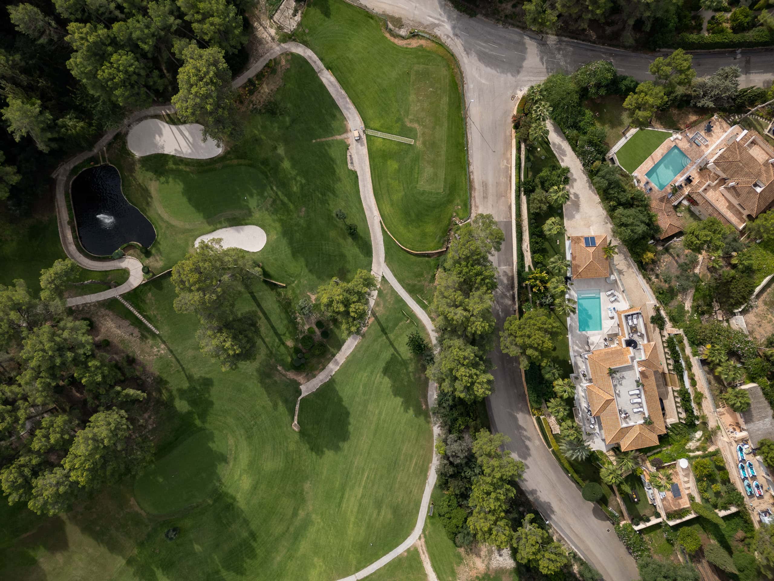 Bird’s-eye view drone photograph of a luxury private villa beside Son Vida Golf Course in Mallorca, showing landscaped fairways, swimming pools, surrounding trees, and Mediterranean-style architecture.