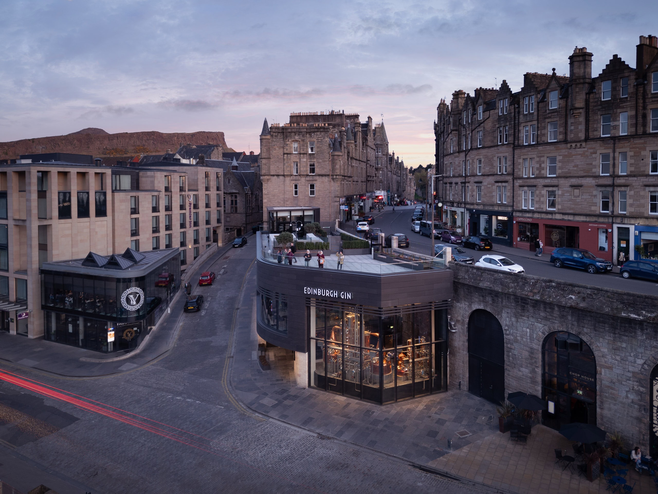 Twilight aerial photograph of the Edinburgh Gin Distillery by Staran Architects featuring contemporary glass architecture integrated within Edinburgh’s historic stone streetscape.