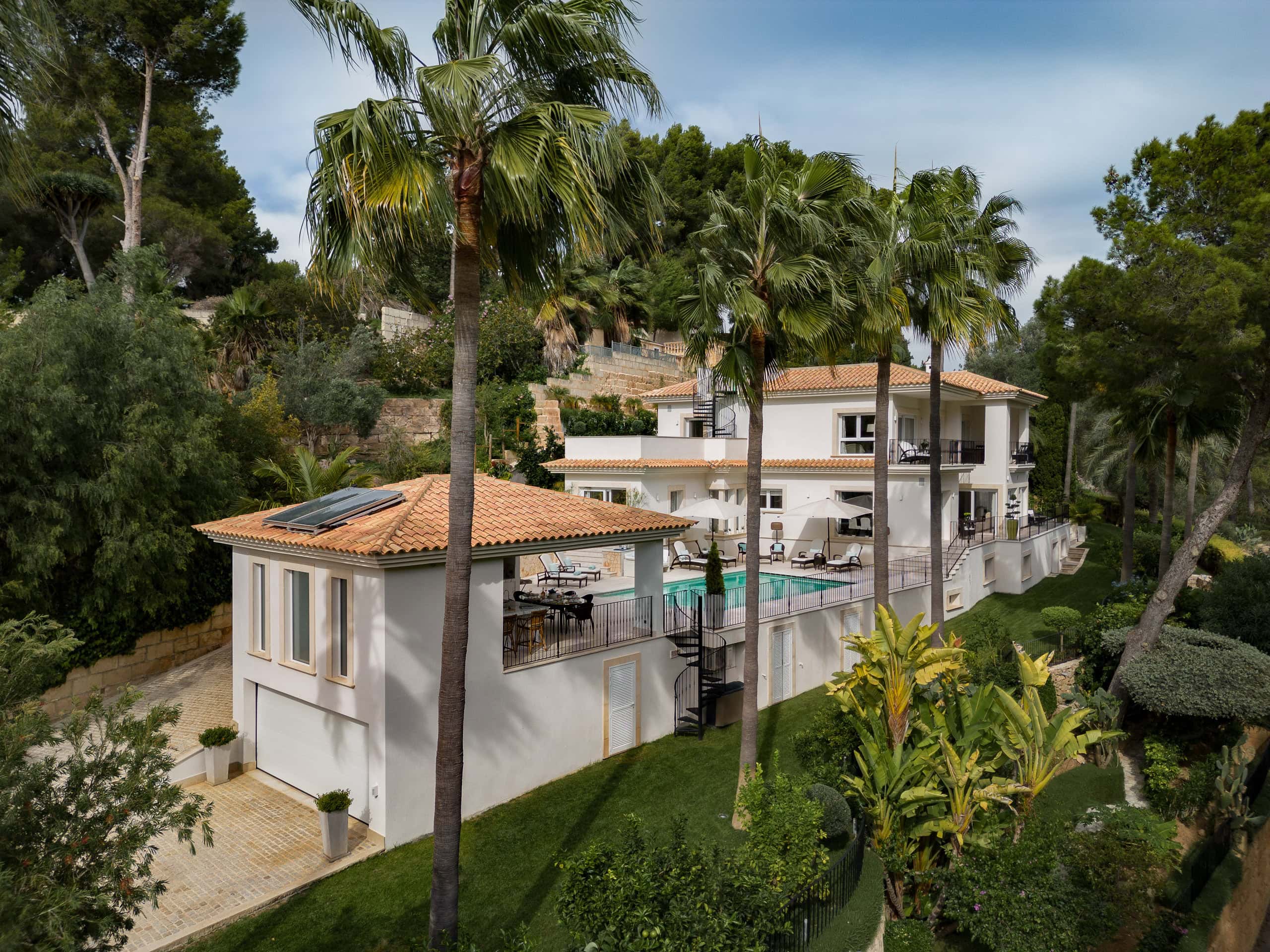 Luxury hillside villa in Son Vida, Mallorca featuring Mediterranean architecture, palm-lined gardens, elevated terraces, and a private swimming pool.