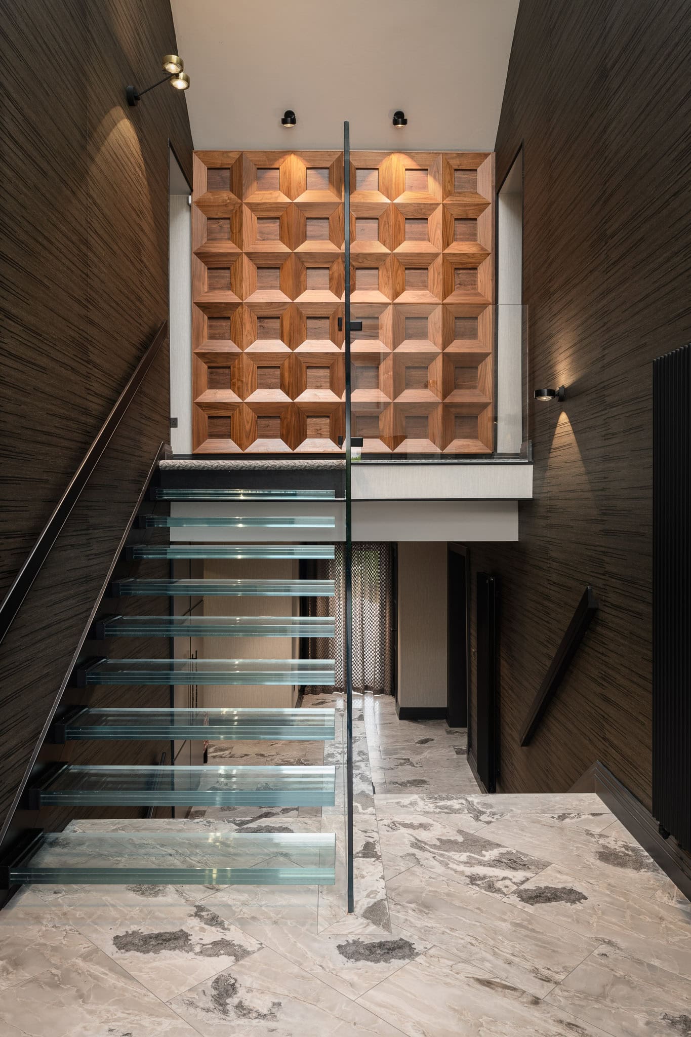 Modern staircase with glass steps and wooden wall feature in contemporary interior.