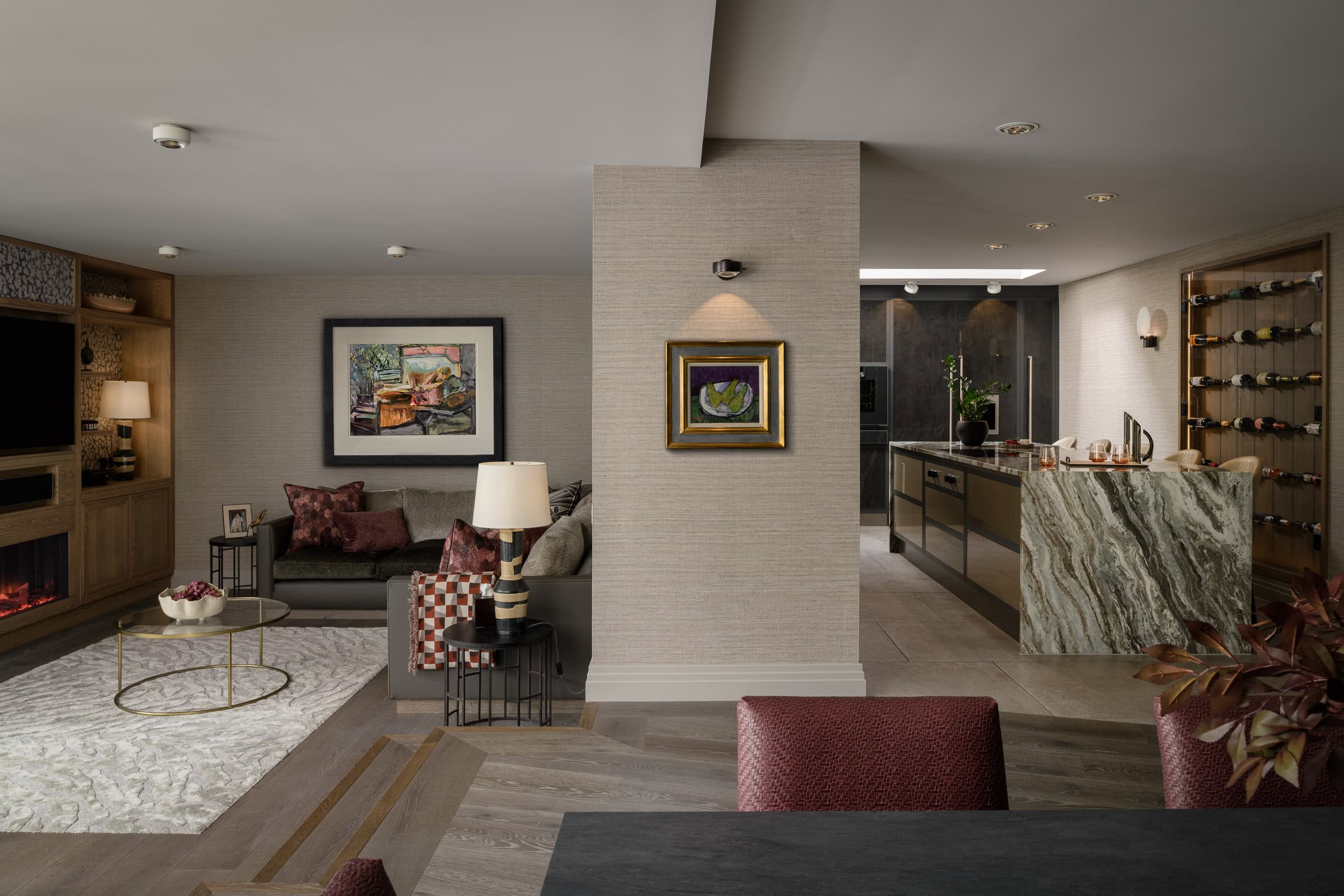 Modern interior living space with artwork, sofa, and kitchen area in the background.