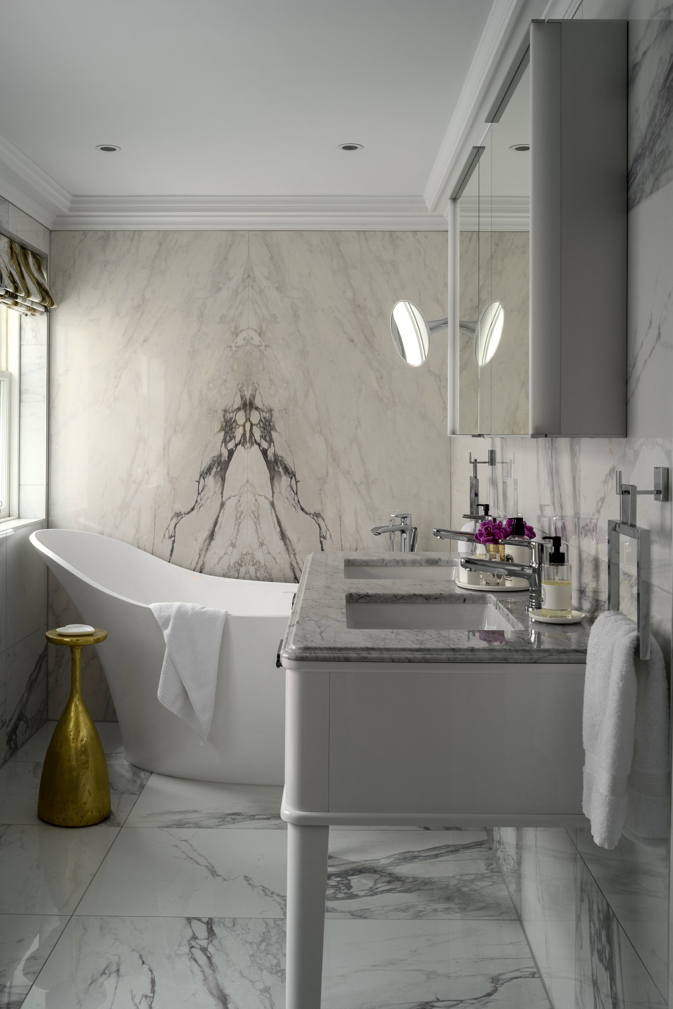 Luxurious bathroom with marble walls and a freestanding bathtub.