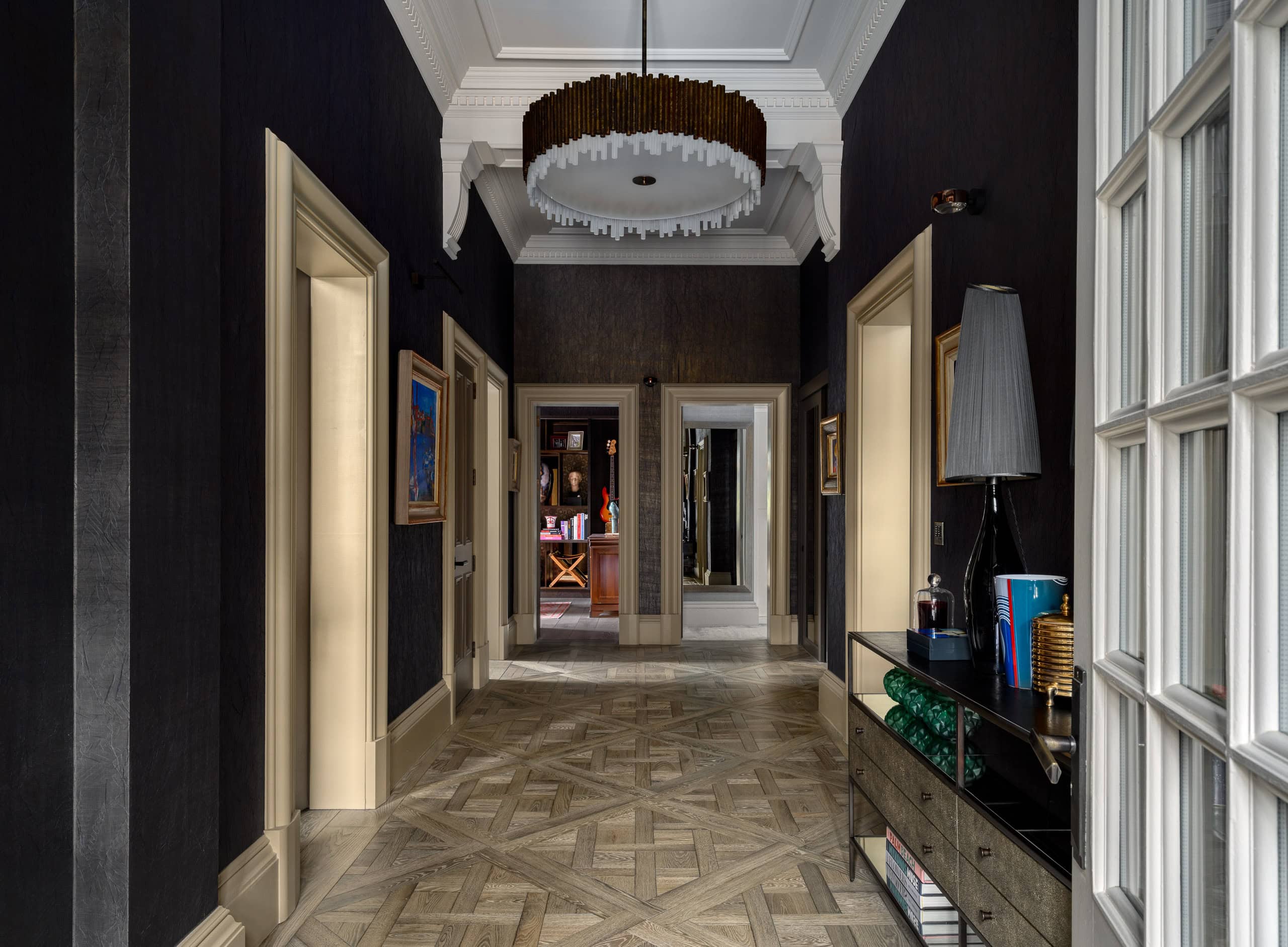 Elegant hallway with dark walls, large windows, and stylish decor.