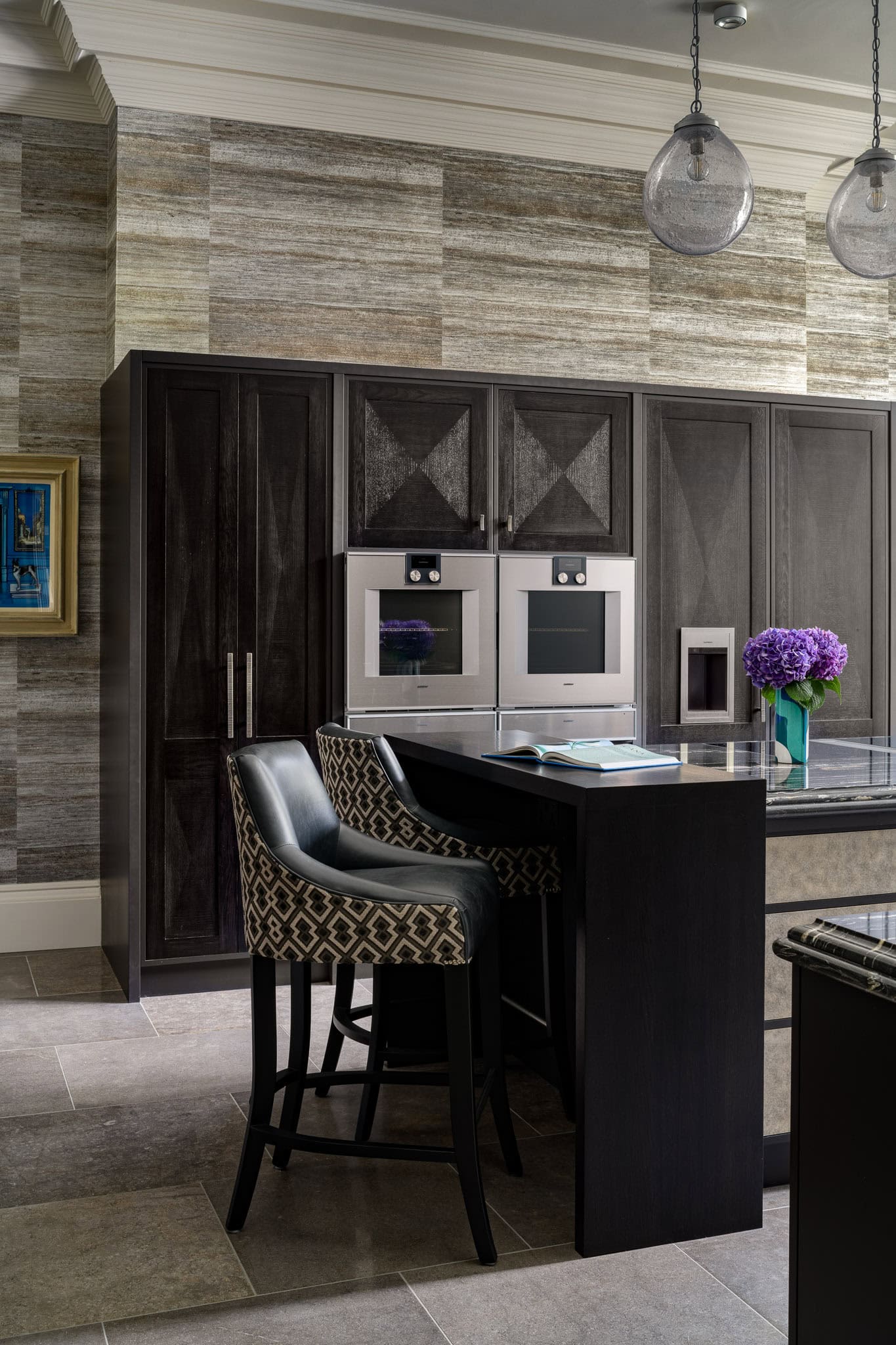 Modern kitchen with dark cabinetry and built-in appliances in a stylish interior.