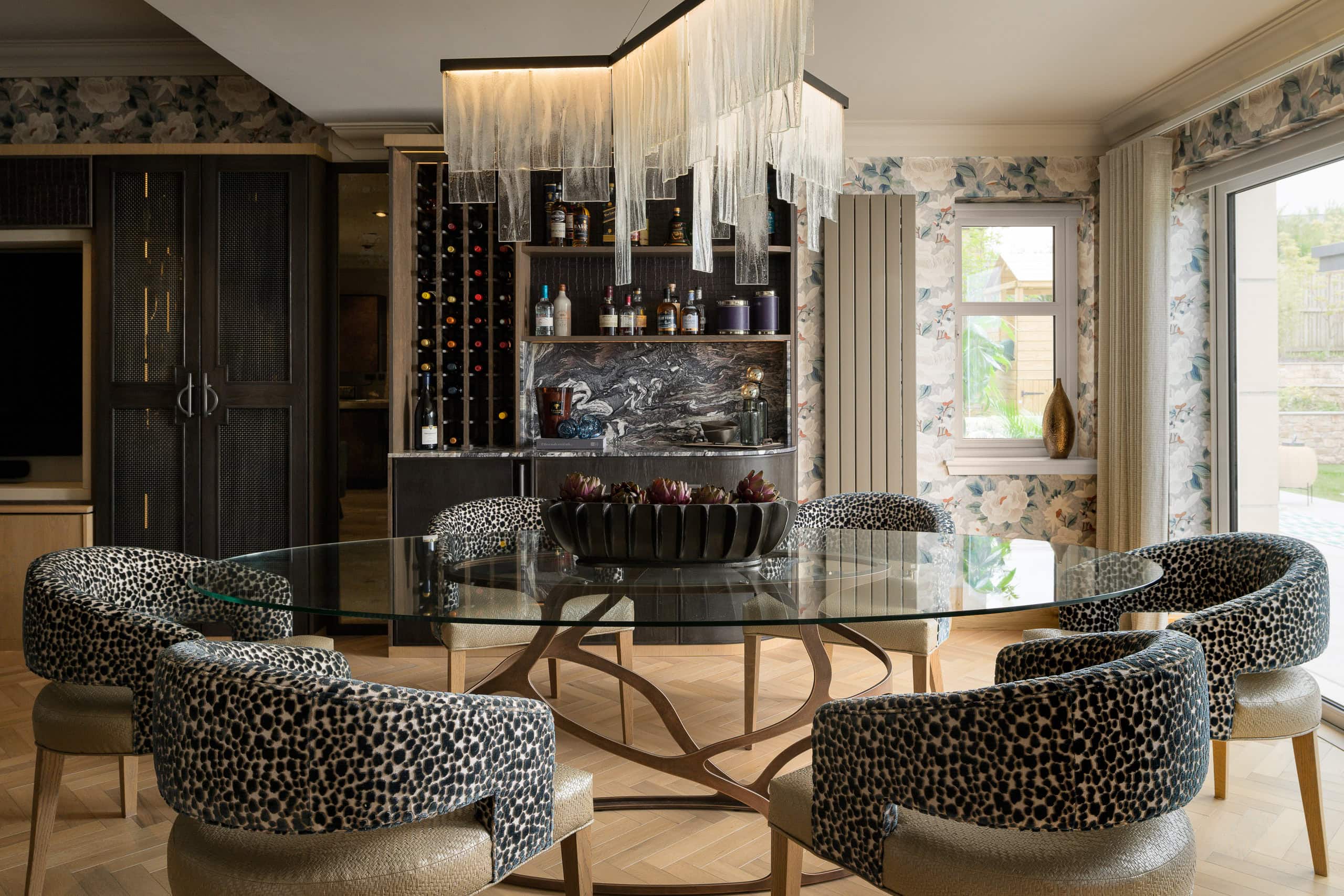 Elegant dining room with modern chandelier and patterned chairs.