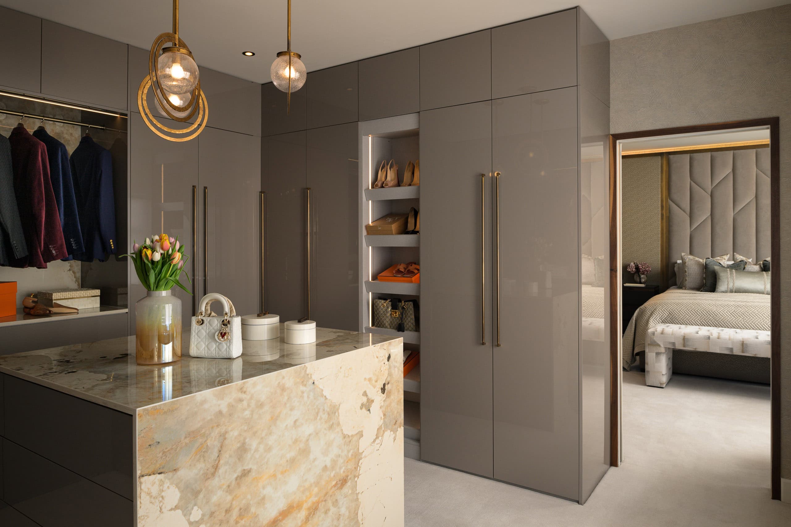 Modern grey wardrobe and walk-in closet with open shelving and bedroom in background.