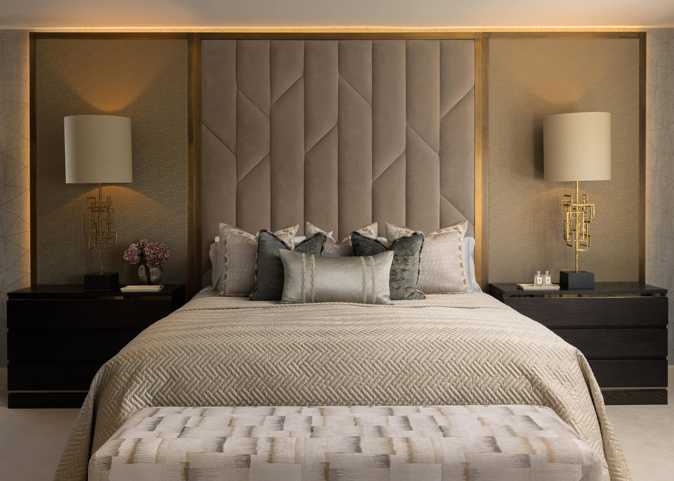 Elegant bedroom interior with plush headboard and modern lighting.
