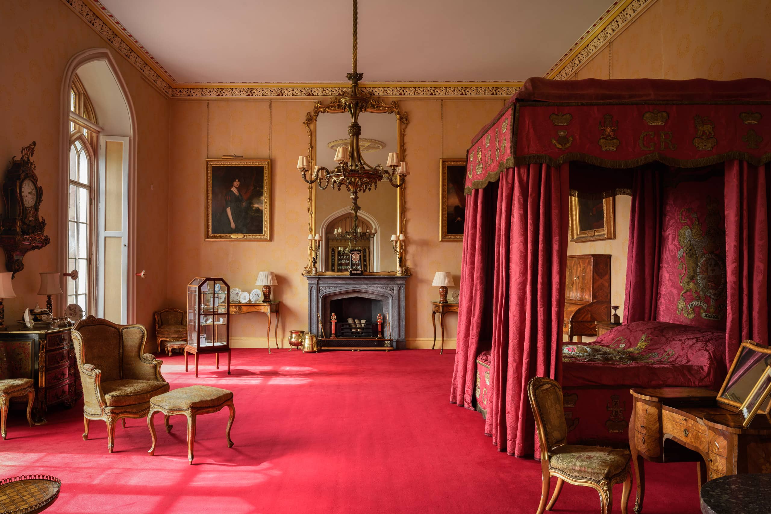 Elegant historic interior with ornate furnishings and a four-poster bed.