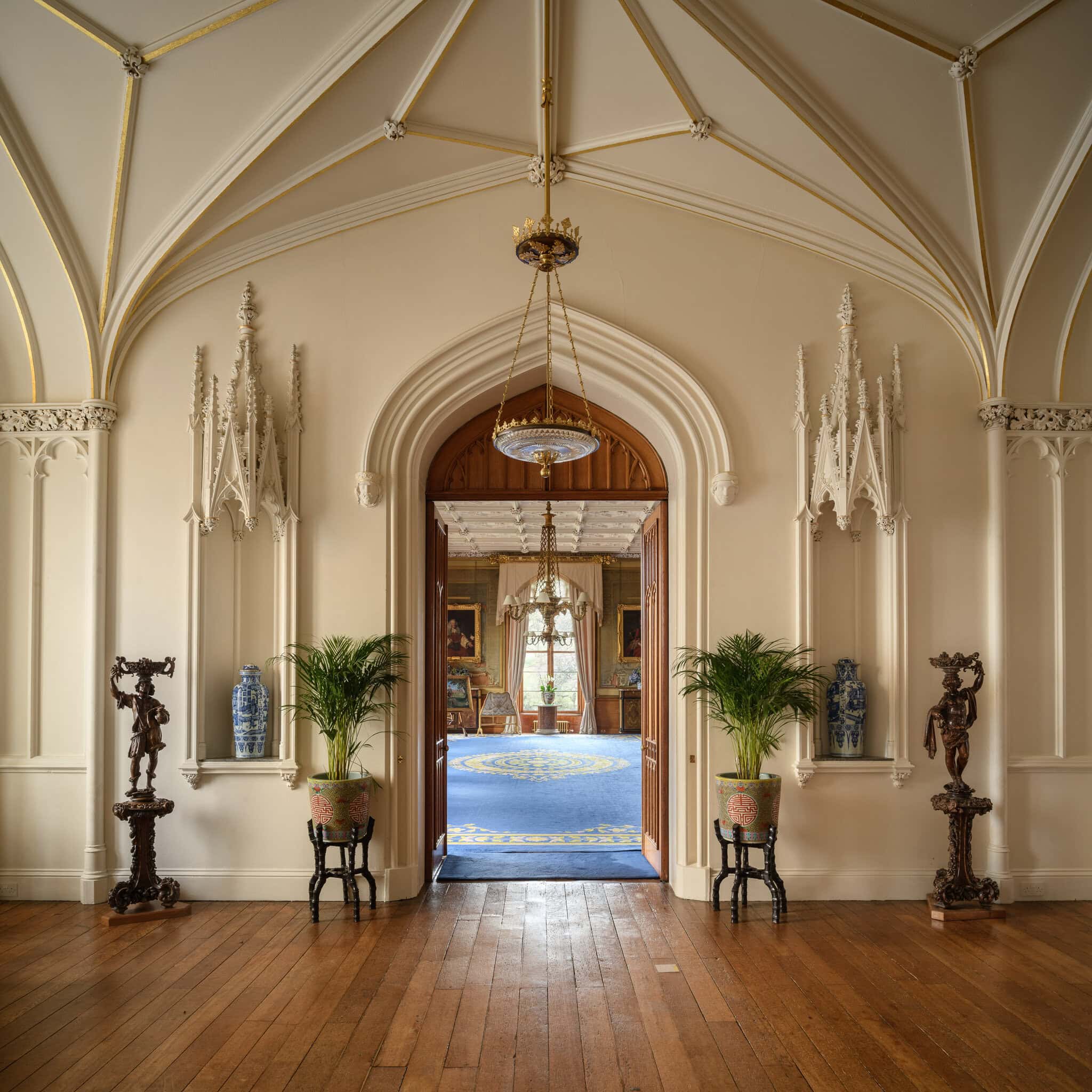 Elegant historic interior with ornate architecture and decorative sculptures.