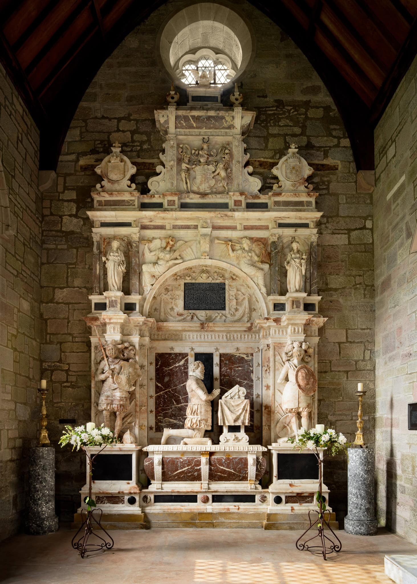 Interior of a historic church with ornate marble altar and sculptures.