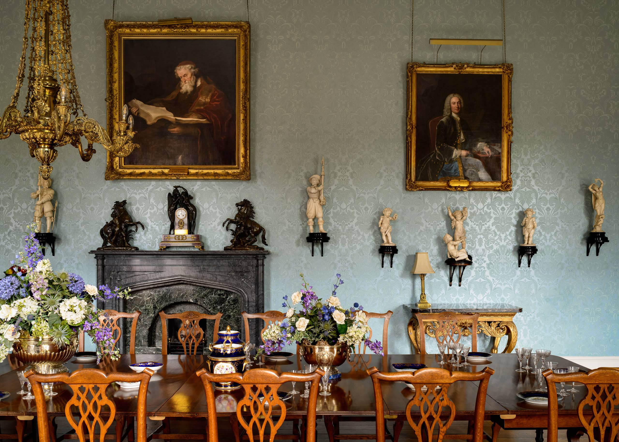 Elegant dining room with antique furniture and classical artwork.
