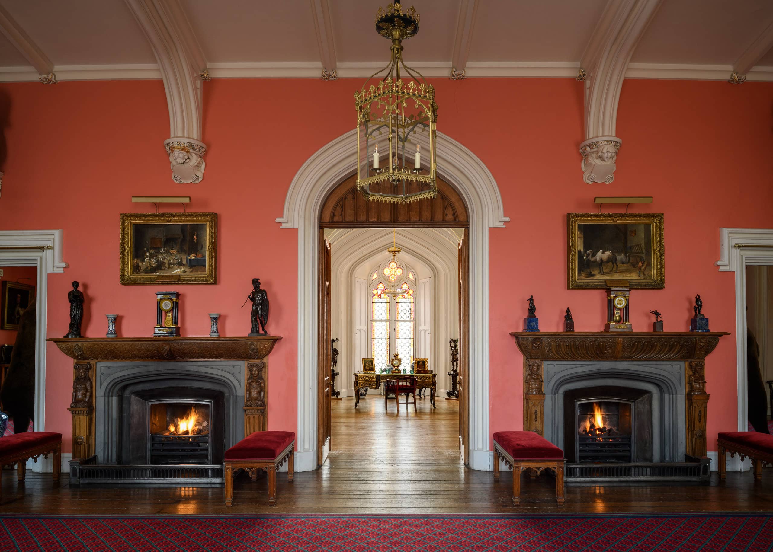 Elegant historic interior with two fireplaces and ornate decor in a grand room.