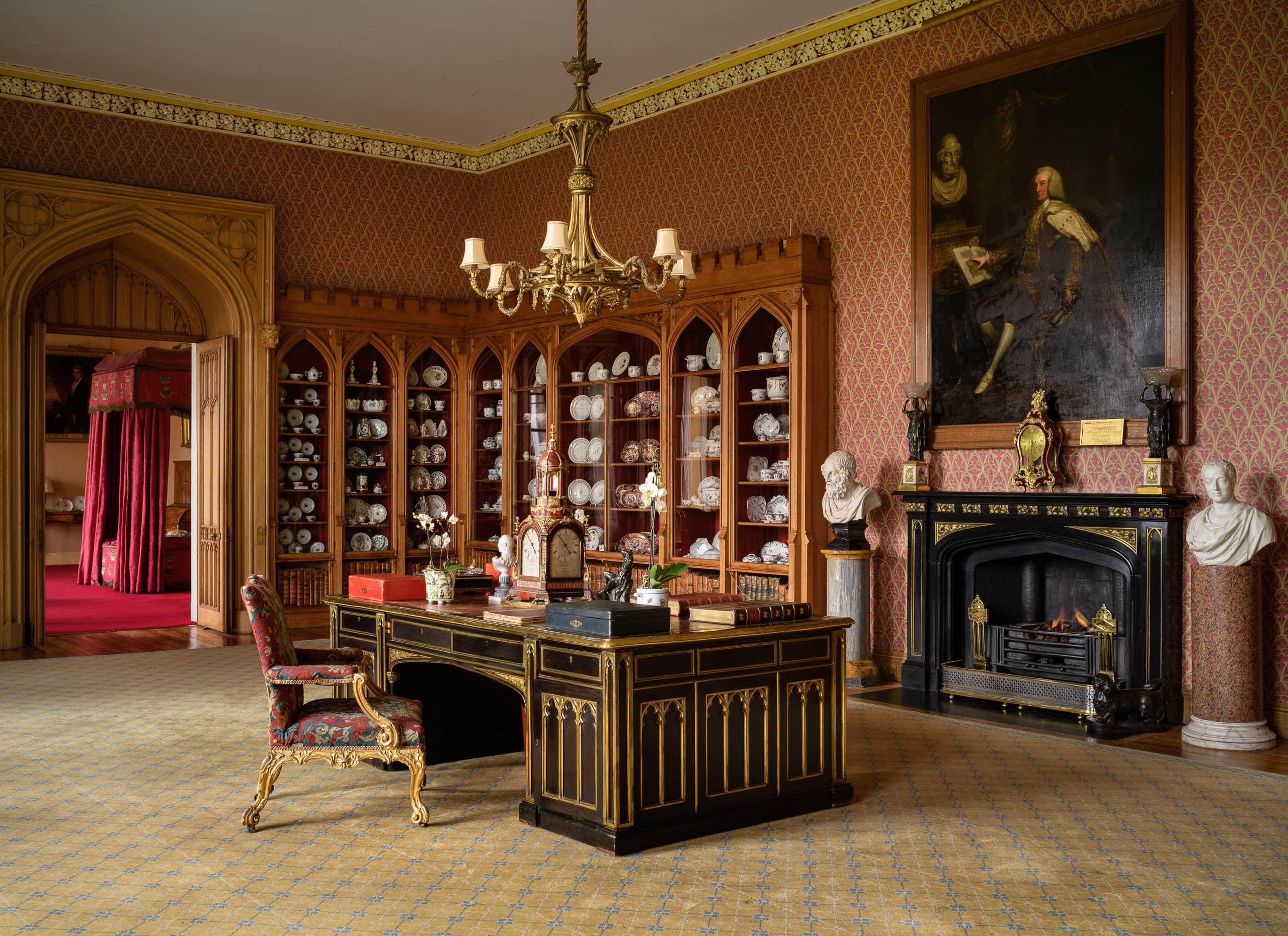 Elegant historic interior with ornate fireplace and antique furniture.