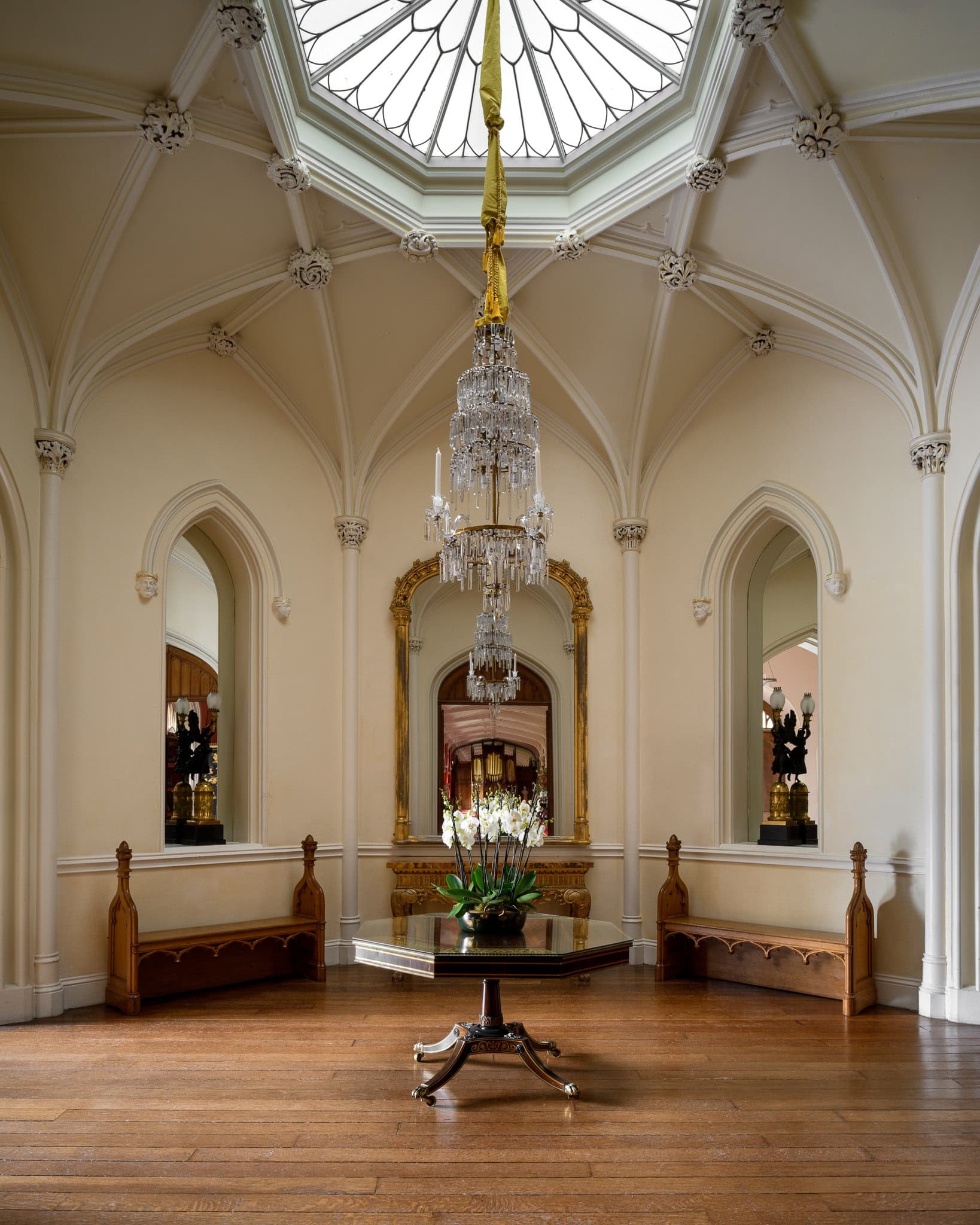 Elegant interior with a chandelier and ornate ceiling in a historic building.